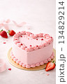 Valentine's pink heart-shaped cake decorated with strawberries on pink background 134829214