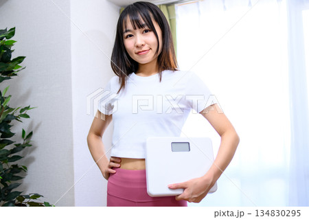 ヨガウェアで体重計を持つ笑顔の日本人女性 ダイエット レギンス トリミングアップ ヨガウェアで体重計を持つ笑顔の日本人女性 ダイエット レギンス トリミングアップ 134830295