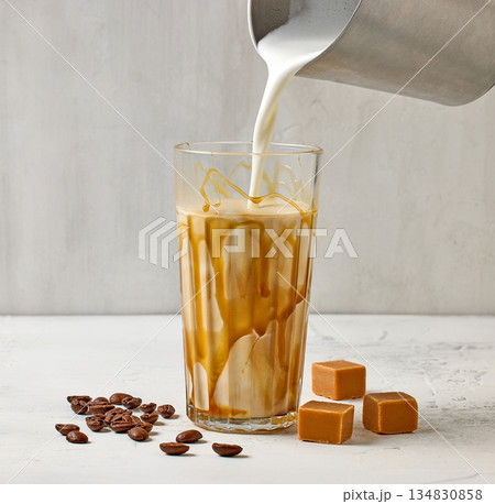 closeup of caramel latte coffee glass on white table background closeup of caramel latte coffee glass on white table background 134830858