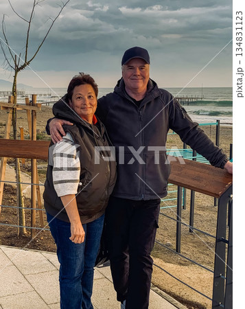 Retired couple relaxing, Couple walking along seaside promenade Retired couple relaxing, Couple walking along seaside promenade 134831123