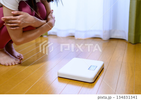 ヨガウェアで体重計を見てショックを受ける女性　ダイエット　レギンス　トリミングアップ 134831341