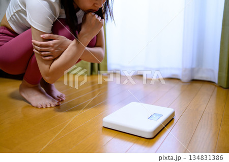 ヨガウェアで体重計を見てショックを受ける女性　ダイエット　レギンス　 134831386