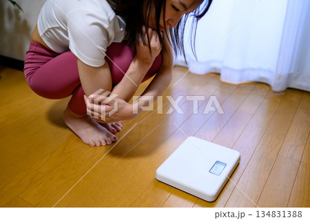 ヨガウェアで体重計を見てショックを受ける女性 ダイエット レギンス ヨガウェアで体重計を見てショックを受ける女性 ダイエット レギンス 134831388