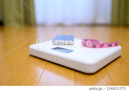 フローリングの上の体重計にスマホと巻き尺を置いて　計測イメージ 134831775