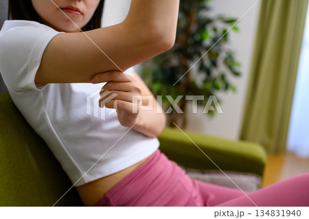 二の腕をつまんでたるみを確認する日本人女性　ダイエット　 134831940