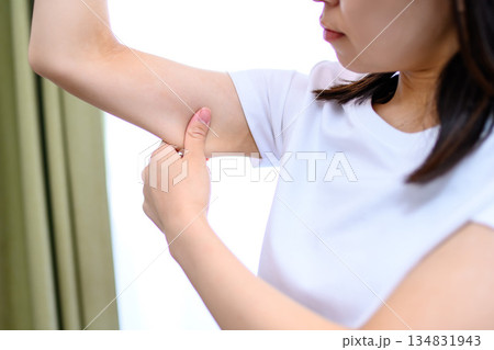 二の腕をつまんでたるみを確認する日本人女性　ダイエット　トリミングアップ 134831943
