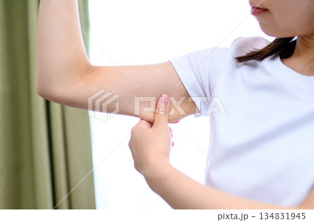 二の腕をつまんでたるみを確認する日本人女性　ダイエット　トリミングアップ 134831945