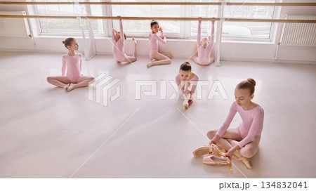 Young ballet students sitting on floor during structured studio lesson. 134832041