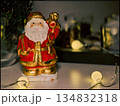 Santa Claus Figurine in Cozy Christmas Setting with String Lights and Decor 134832318
