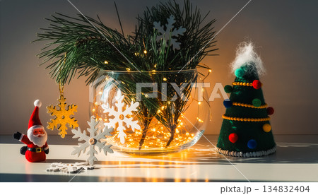 Glass Bowl with Pine Branches, Felt Tree and Santa Figurine on White Surface with Warm Lights 134832404