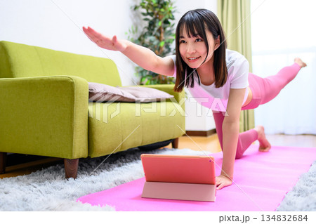 バードドッグ タブレットでYouTube動画を見ながら自宅で柔軟、ヨガをする若い女性 ヨガウェア バードドッグ タブレットでYouTube動画を見ながら自宅で柔軟、ヨガをする若い女性 ヨガウェア 134832684