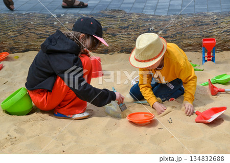 Boy and girl playing on the beach on summer holidays. Children building a sandcastle at the sea. High quality photo 134832688