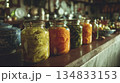 Ambient Evening Illumination Highlights Rustic Jars Filled With Tangy Fermented Vegetables On Countertop 134833153
