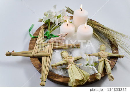 Imbolc altar with brigid's cross, dolls, candles, and lamb 134833285