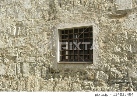 Small Square Barred Window in a Rough Stone Wall 134833494