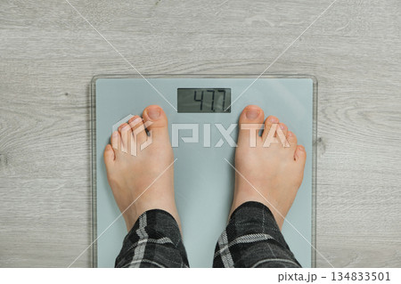 Top View of Bare Feet Standing on Modern Digital Bathroom Scales for Weighing. 134833501