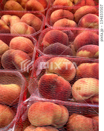 Fresh Peaches in Red Mesh Packaging on Supermarket Display 134833507