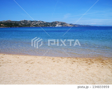 Beautiful beach view in Olbia, Sardinia, featuring crystal-clear turquoise water, white sandy shore, and the pristine Mediterranean coastline. Sunlit sea, gentle waves, and a relaxing coastal Beautiful beach view in Olbia, Sardinia, featuring crystal-clear turquoise water, white sandy shore, and the pristine Mediterranean coastline. Sunlit sea, gentle waves, and a relaxing coastal 134833959