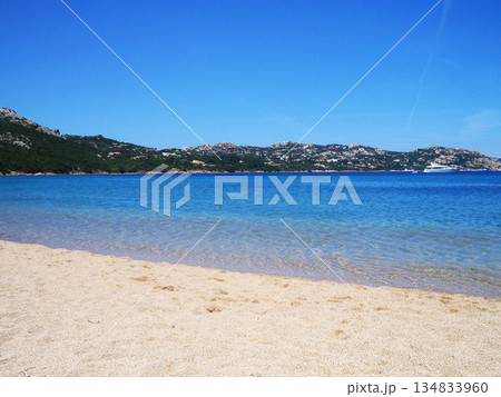 Beautiful beach view in Olbia, Sardinia, featuring crystal-clear turquoise water, white sandy shore, and the pristine Mediterranean coastline. Sunlit sea, gentle waves, and a relaxing coastal 134833960