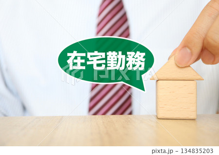 在宅勤務を示す吹き出しと家のブロックを持つビジネスマン。 134835203