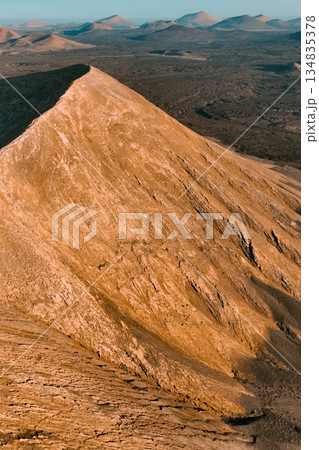A volcano crater, beautiful volcanic mountains of Lanzarote, Canary islands at sunset. A volcano crater, beautiful volcanic mountains of Lanzarote, Canary islands at sunset. 134835378
