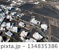White buildings, town among volcanic black mountains and lava formations in Lanzarote, Canary Islands. 134835386