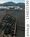 White buildings, town among volcanic black mountains and lava formations in Lanzarote, Canary Islands. 134835390