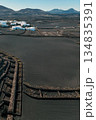 White buildings, town among volcanic black mountains and lava formations in Lanzarote, Canary Islands. 134835391