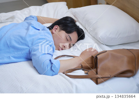 私服でベッドで寝る疲労した男性 私服でベッドで寝る疲労した男性 134835664