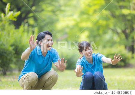 子供と遊ぶ青いポロシャツの男女スタッフ  134836667