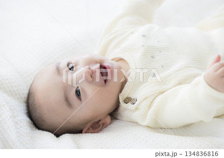 ベッドに寝転ぶ赤ちゃん　　　　 134836816