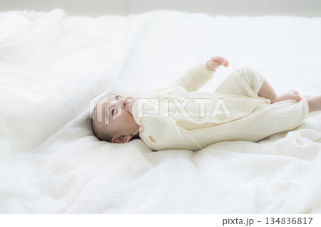 ベッドに寝転ぶ赤ちゃん ベッドに寝転ぶ赤ちゃん 134836817