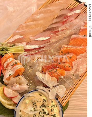 Fresh and delicate sashimi slices, beautifully presented with vibrant colors and perfect cuts. This traditional Japanese delicacy highlights the pure flavors of premium seafood. 134837254