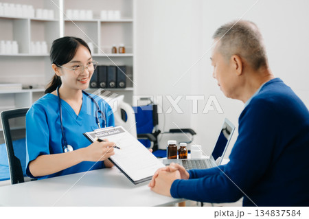 Asia female doctor using clipboard is delivering great news talk discuss results or symptoms with female patient in clinic Asia female doctor using clipboard is delivering great news talk discuss results or symptoms with female patient in clinic 134837584