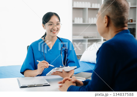 Asia female doctor using clipboard is delivering great news talk discuss results or symptoms with female patient in clinic 134837588