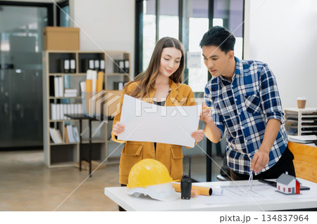 Engineer teams meeting working together wear worker helmets hardhat with on architectural project site and making model house. Engineer teams meeting working together wear worker helmets hardhat with on architectural project site and making model house. 134837964