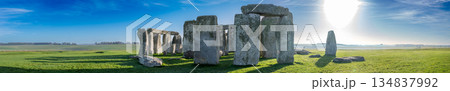 Visitors explore Stonehenge in the early morning light surrounded by green grass and clear skies Visitors explore Stonehenge in the early morning light surrounded by green grass and clear skies 134837992