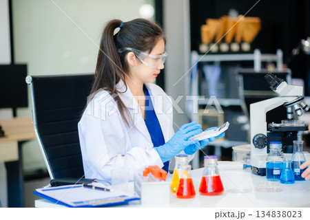 Female biotechnologist testing new chemical substances in a laboratory. 134838023