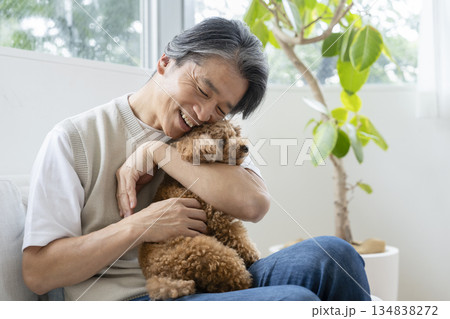 トイプードルを抱く50代の男性　犬との暮らしイメージ 134838272