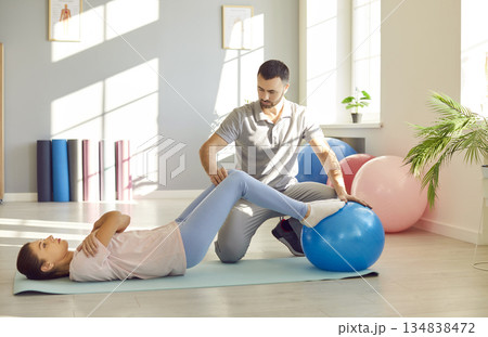 Caucasian Woman Fitness Exercise Using Ball With Personal Trainer 134838472