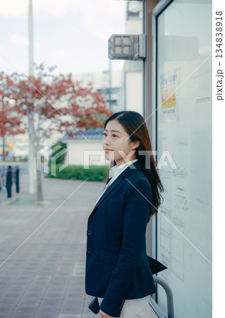 バス停で就職活動を考える日本人女子大学生 134838918