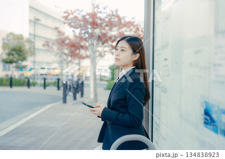 バス停で就職活動を考える日本人女子大学生 134838923