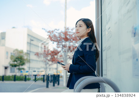 バス停で就職活動を考える日本人女子大学生 134838924