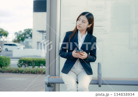 バス停で就職活動を考える日本人女子大学生 バス停で就職活動を考える日本人女子大学生 134838934