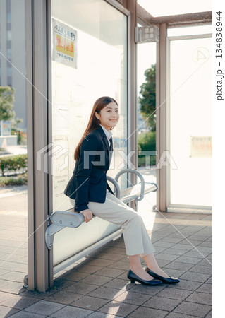 バス停で就職活動を考える日本人女子大学生 134838944