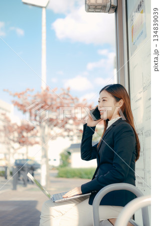 バス停でパソコンとスマホを使う日本人女子大学生 バス停でパソコンとスマホを使う日本人女子大学生 134839039