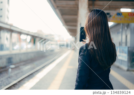 駅のホームでスマホを操作する日本人女子大学生 134839124