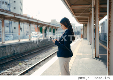 駅のホームでスマホを操作する日本人女子大学生 駅のホームでスマホを操作する日本人女子大学生 134839129