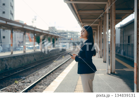 駅のホームでスマホを操作する日本人女子大学生 駅のホームでスマホを操作する日本人女子大学生 134839131