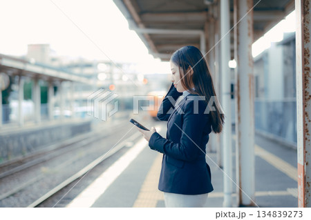 駅のホームでスマホを手に電車を待つ日本人女子大学生 駅のホームでスマホを手に電車を待つ日本人女子大学生 134839273